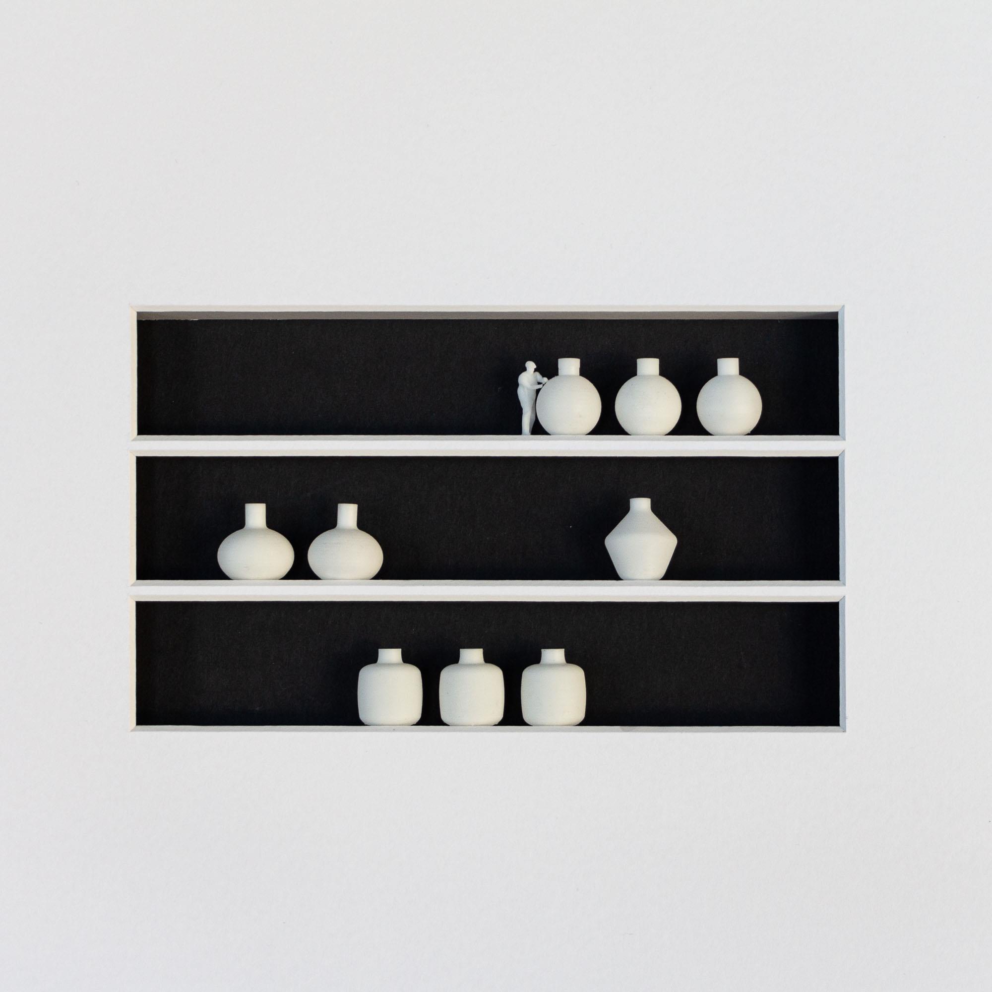 3d printed artwork of miniature person and vases in black frame