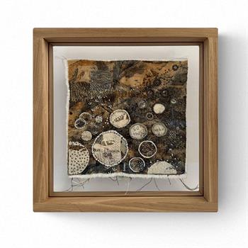 hand stitched textile artwork in wood frame
