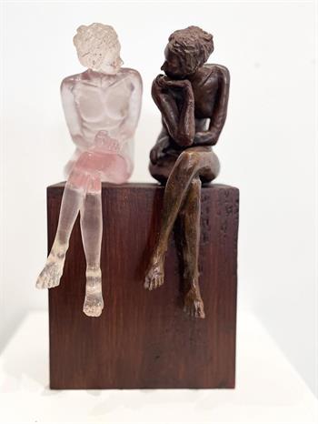 bronze and resin sculpture of two nude female figures in discussion