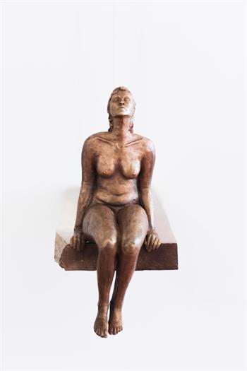 bronze sculpture of a nude woman seated on a diving board