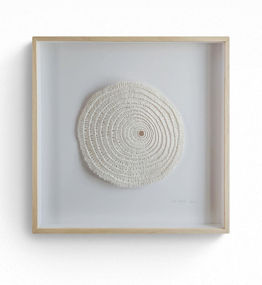 framed circular wall sculpture made from clay