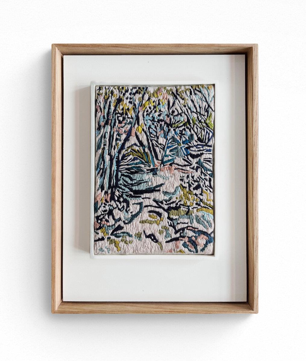 small embroidered painting of a forest landscape