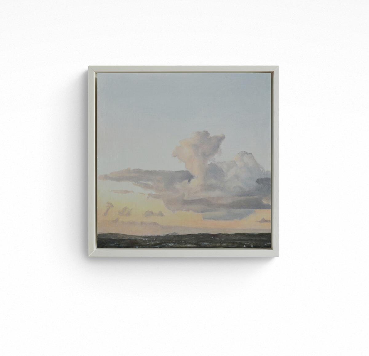 small framed painting of clouds lit by the setting sun