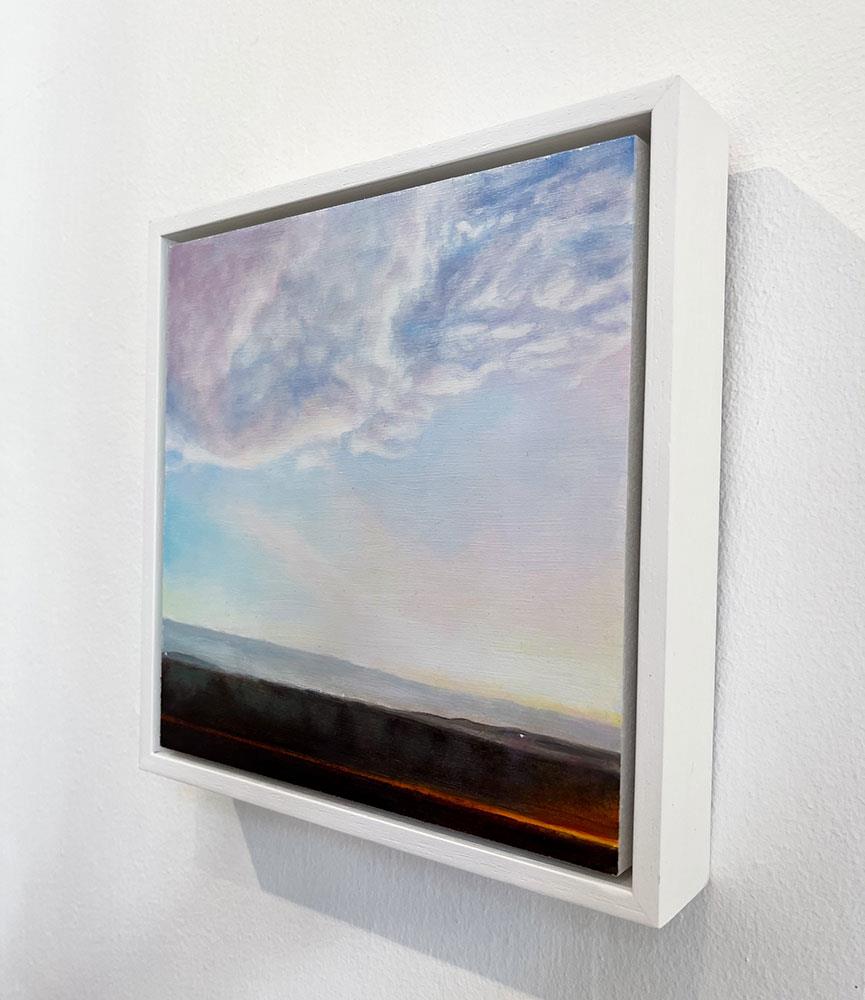 small framed painting of pink clouds in a dusk sky