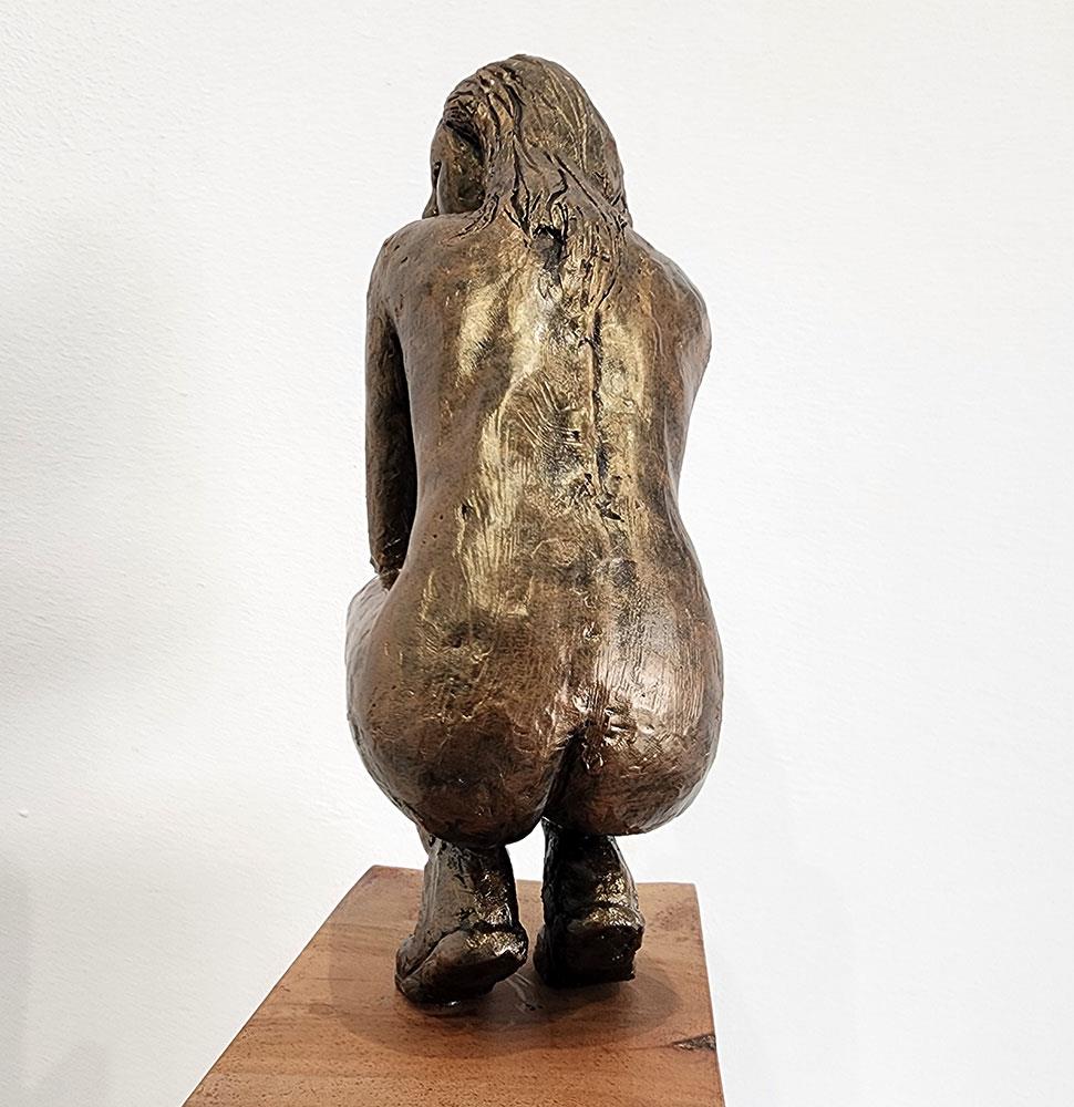 sculpture of a nude crouching female figure