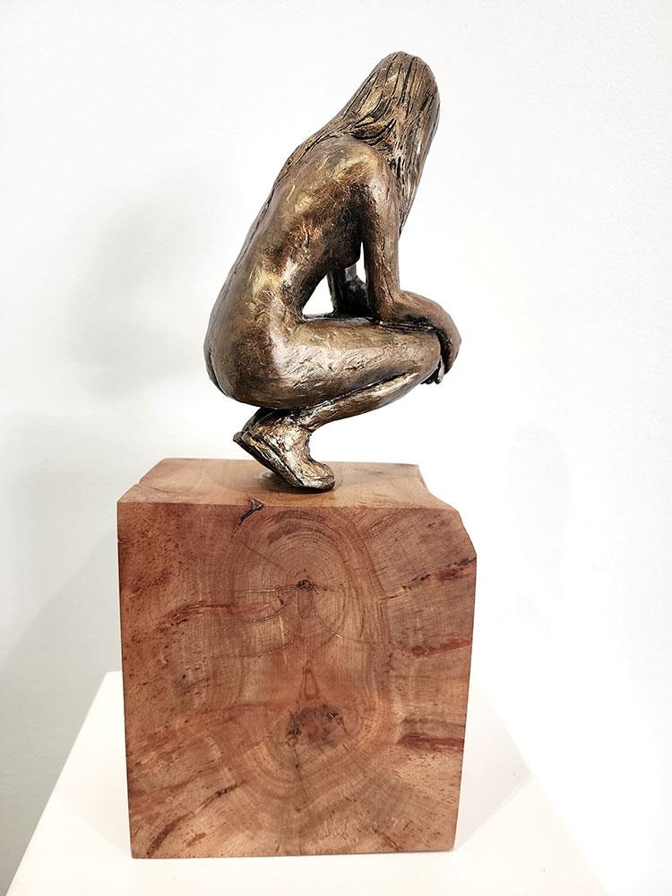 sculpture of a nude crouching female figure