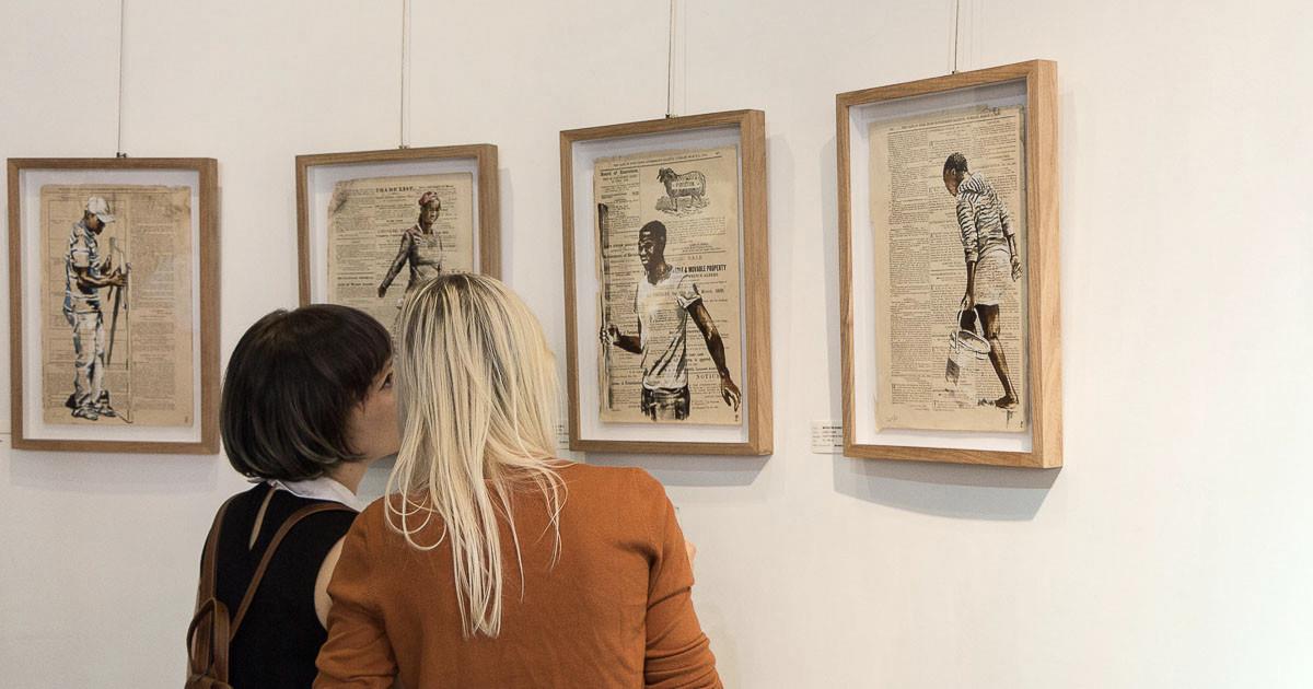 Women looking at 4 framed artworks by Lisette Forsyth on the wall.