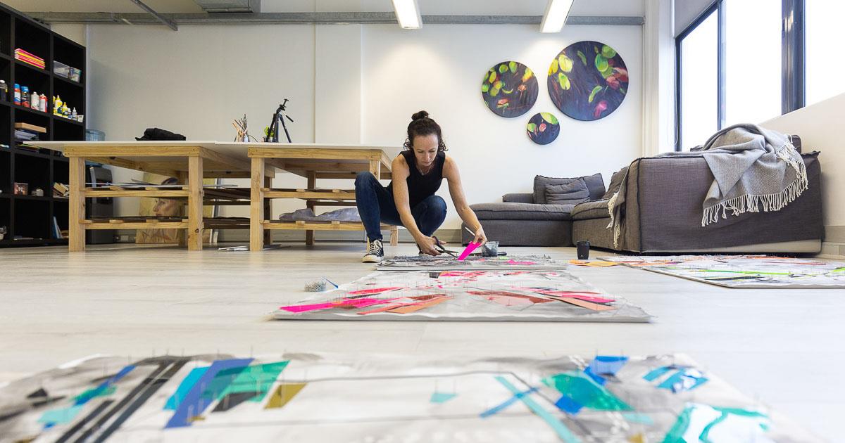 Tanya Sternberg in her studio, working on abstract artworks laid out on the floor