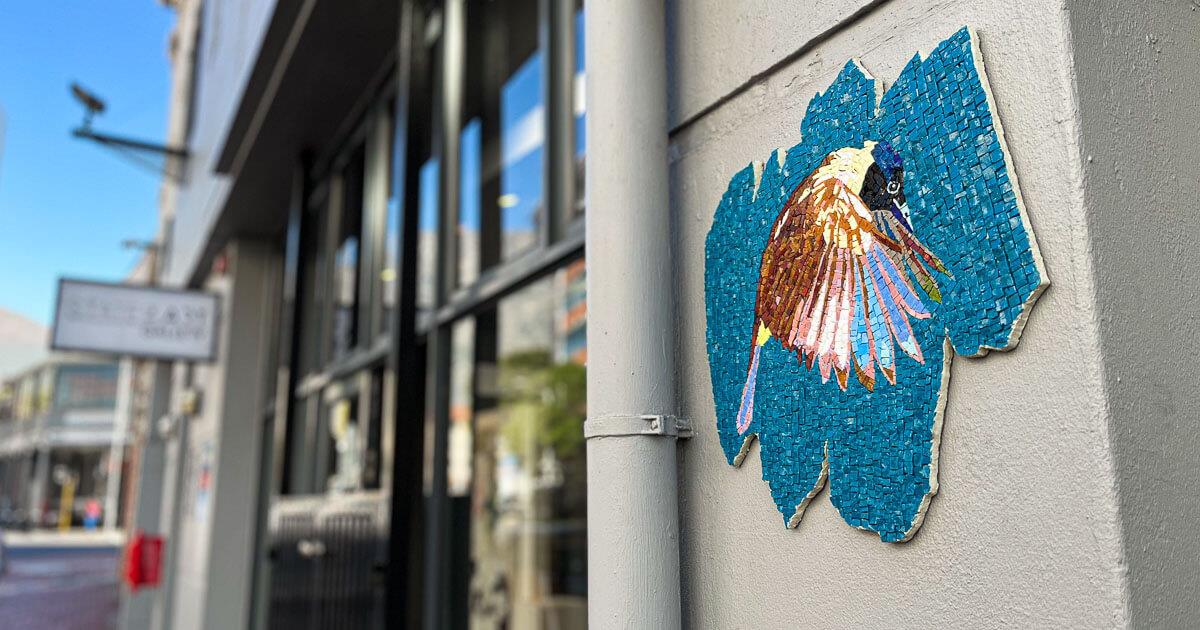 A mosaic artwork of a bird on the wall outside StateoftheART Gallery in Cape Town.