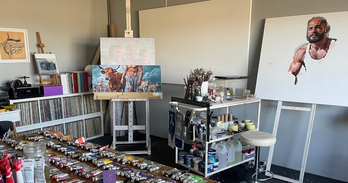 Wide view of artist Corné Eksteen's studio with paintings, works in progress and materials